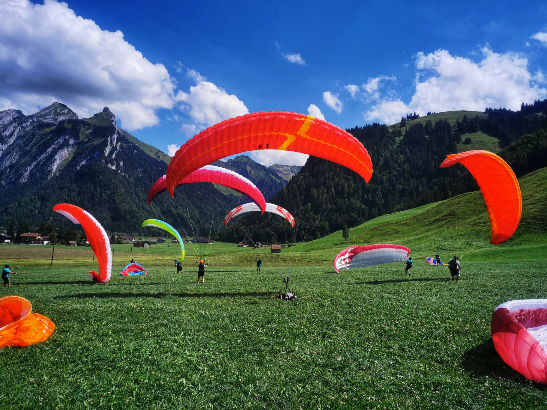 Gleitschirmpilot beim Groundhandling auf einem alpinen Grat im Morgenlicht